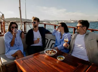 Cuatro amigos tomando bebidas durante su paseo en barco por Barcelona