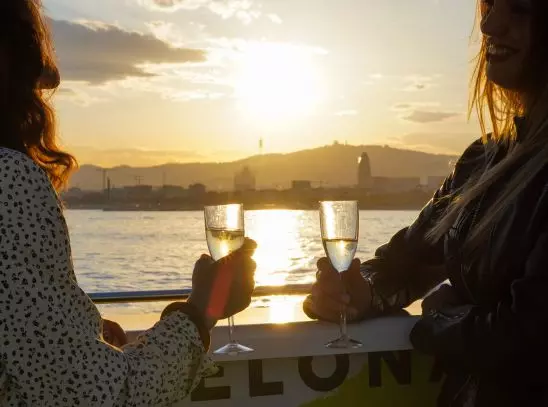 Dos turistas bebiendo champagne a bordo del barco en Barcelona